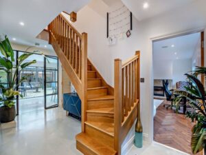 entrance hall with polished concrete floor and oak staircase in a house for sale on the Wirral